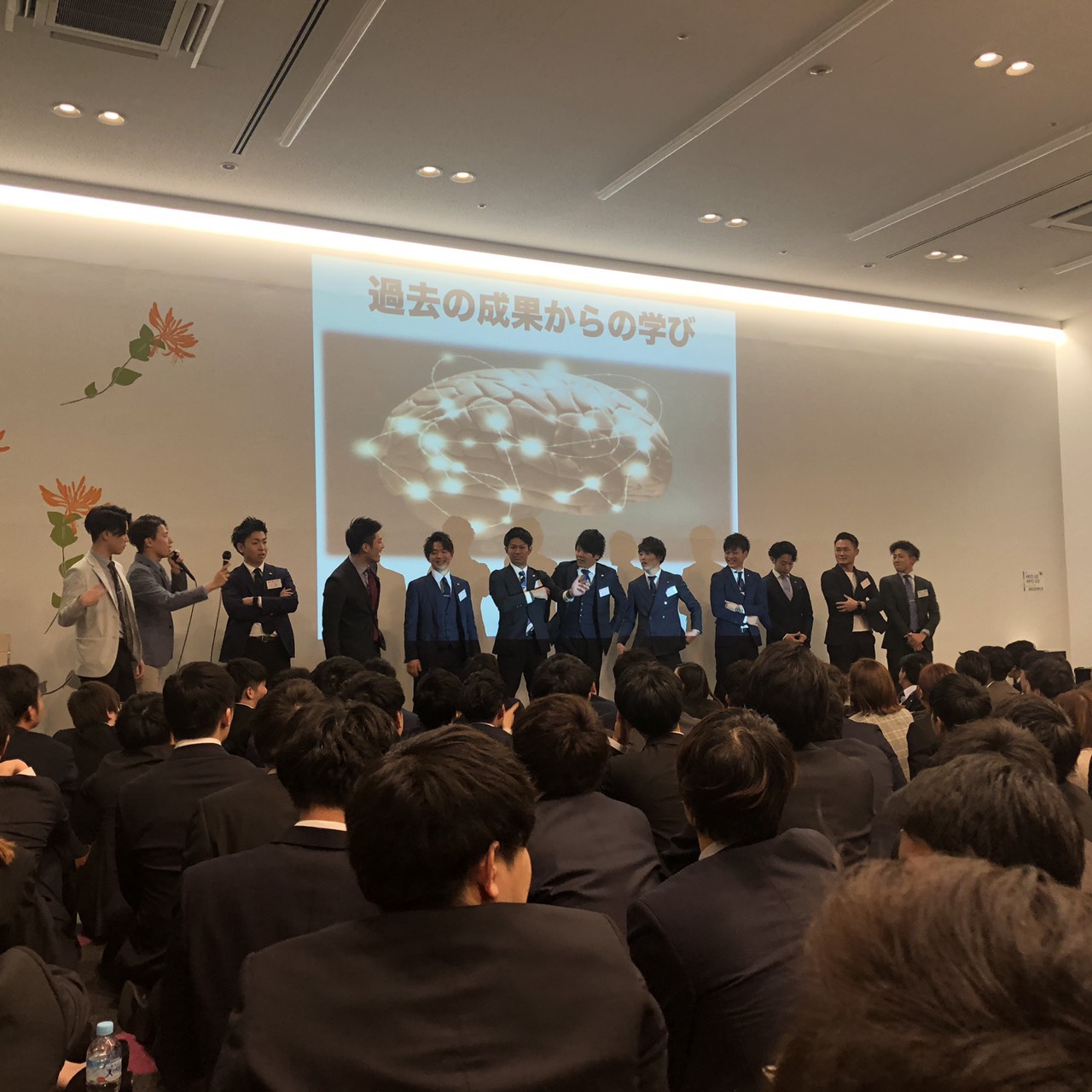 大人数の前で成果を共有する場面